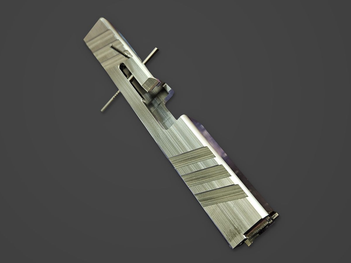 Machined stainless steel slide on a charcoal ground