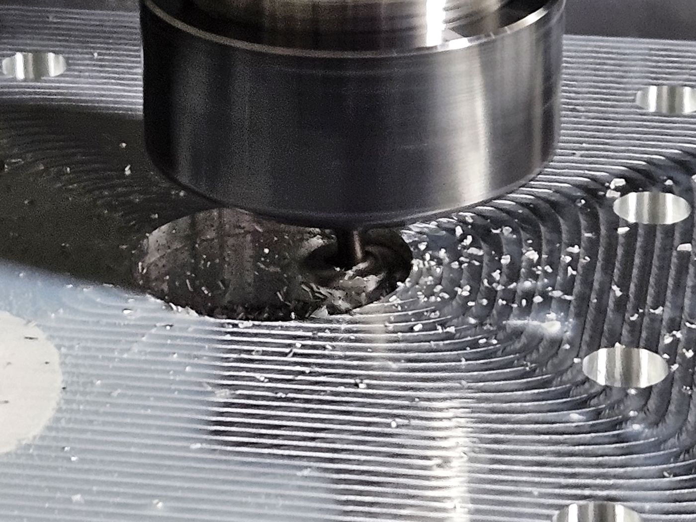 A cutter on the spindle milling a pocket in an aluminum plate